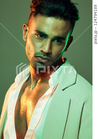 Skincare, wellness and man in studio with neon, green and light for beauty, health and grooming on a green background. Face, skin and indian model on creative mockup for product, sexy and aesthetic 124794189