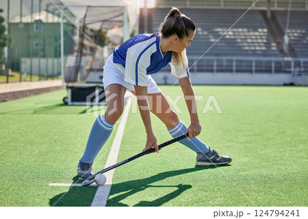 Sports, hockey and woman in action on field with hockey stick ready to hit ball in game. Fitness, exercise and female athlete playing field hockey in outdoor stadium for workout, training and health Sports, hockey and woman in action on field with hockey stick ready to hit ball in game. Fitness, exercise and female athlete playing field hockey in outdoor stadium for workout, training and health 124794241