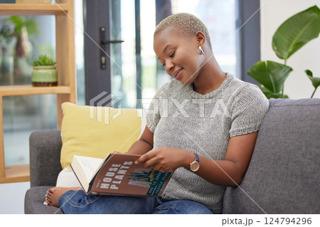 Plant care, learning and woman reading gardening book for instructions, tips and ideas for home garden. Greenery, nature and black woman relaxing, sitting on sofa and read manual for house plants 124794296