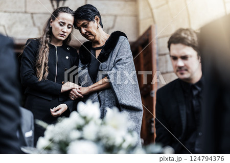 Funeral, senior mother and woman sad, crying and death in family, church and grief for loss of life. Young female comfort, care and support elderly mom after ceremony or service outdoor a chapel 124794376
