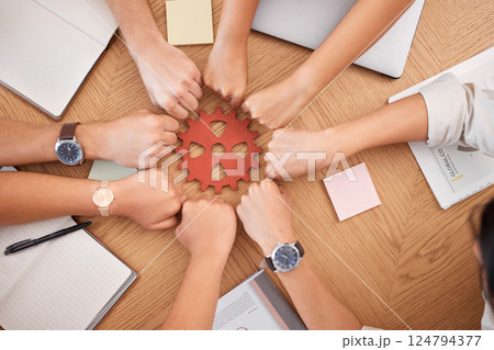Hands, collaboration and gear with a business team working together at a table in the office from above. Teamwork, planning and synergy with a man and woman employee group in a huddle or circle Hands, collaboration and gear with a business team working together at a table in the office from above. Teamwork, planning and synergy with a man and woman employee group in a huddle or circle 124794377