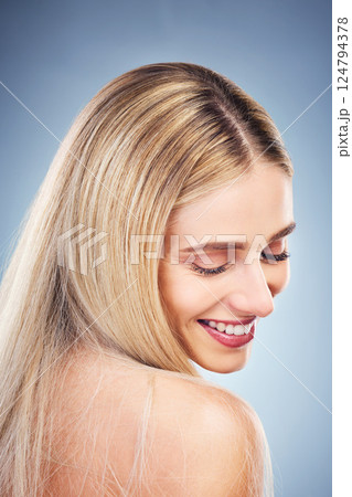 Beauty, hair and wellness model happy with glossy, shiny and healthy cosmetic product. Blonde hair, happiness and smile of young woman for hair care marketing in gray studio background. Beauty, hair and wellness model happy with glossy, shiny and healthy cosmetic product. Blonde hair, happiness and smile of young woman for hair care marketing in gray studio background. 124794378