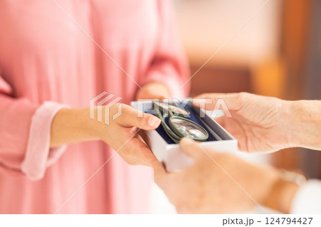 Optometry, eyewear and woman with glasses in a box after shopping in a retail optical store. Closeup of an optometrist helping a patient with her new spectacles in a case at an optics shop or clinic. 124794427