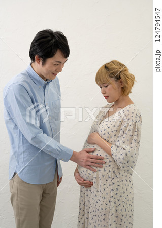 妊娠中の妻のお腹に手をあてる夫 124794547