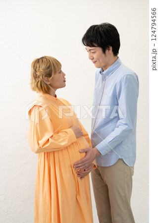 妊娠中の妻のお腹に手をあてる夫 124794566