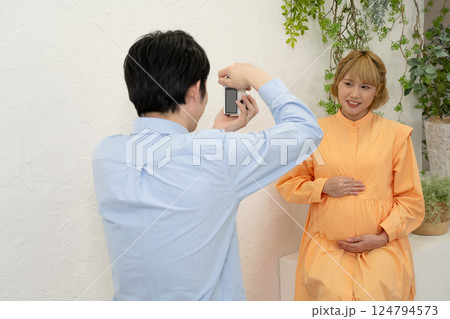 妊娠中の妻の写真を撮る夫 妊娠中の妻の写真を撮る夫 124794573