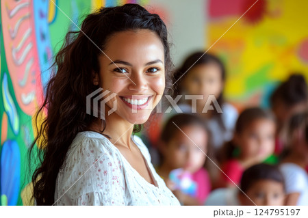Smiling woman with long hair in a colorful classroom, surrounded by children. Concept of happiness, education, diversity. For photo of a positive learning environment. 124795197