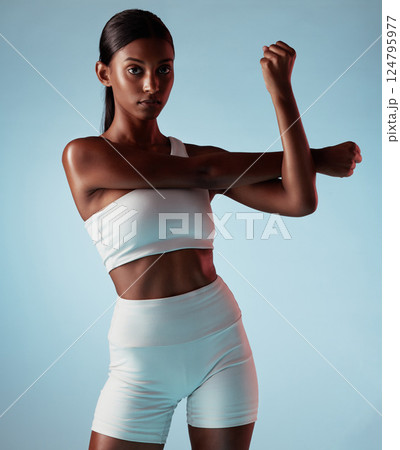 Fitness, body and stretching black woman in studio for exercise, workout or wellness lifestyle portrait with mock up advertising or marketing. Young sports woman with training fashion on blue mockup 124795977