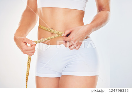 Health, weightloss diet and woman with tape measure to track training exercise results, workout progress and body goals. Wellness lifestyle, motivation and healthy fitness model measure stomach waist 124796333