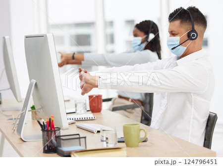 Covid, call center and customer service team stretching for health and wellness after finish or task complete. Contact us, covid 19 and sales agents or employees relaxing with hand stretch in office 124796451