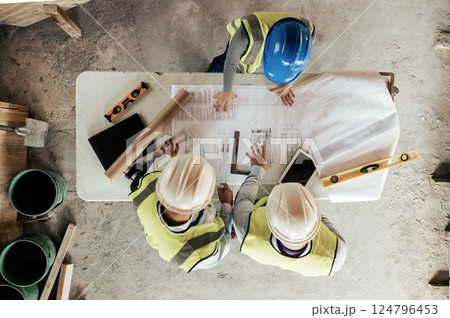 Architect, construction and blueprint with an engineer and designer team working on a building site from above. Meeting, planning and architecture with a design group in collaboration on a project 124796453