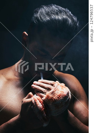 Boxer man, fight and blood of a boxing fighter with cigarette after training accident and a injury. Smoking fitness, workout exercise and wellness athlete smoke with a hand bandage from sport 124796537