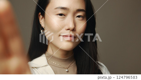 Asian woman, portrait and selfie in studio with beauty, natural cosmetics or smile. Influencer, confident or POV on gray background for photography, social media engagement or makeup tutorial results 124796583