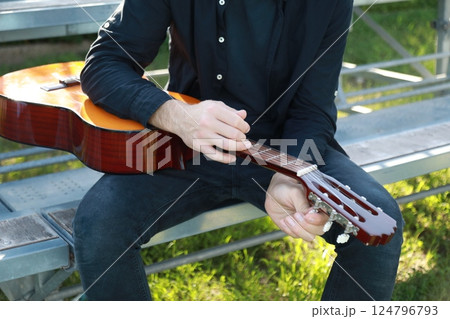 Man's Hand Passes Guitar Strings Preparatively Man's Hand Passes Guitar Strings Preparatively 124796793