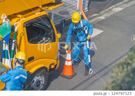 高所作業車　カラーコーン　パイロン　コーンバーを設置する作業員　作業準備 124797123