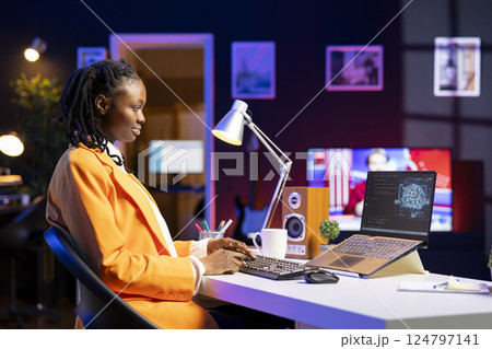 Freelancing computer engineer doing maintenance on artificial intelligence systems. Remote tech support specialist working from home, doing checkup on AI systems using laptop 124797141