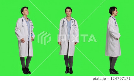 Portrait of physician wearing a white coat and a stethoscope for exams, standing against greenscreen backdrop. Doctor specialist working in healthcare industry, medical expertise. Camera A. 124797171