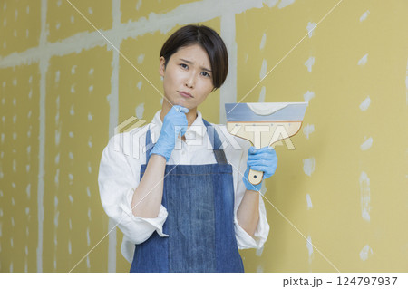 石膏ボードにパテをする女性 124797937