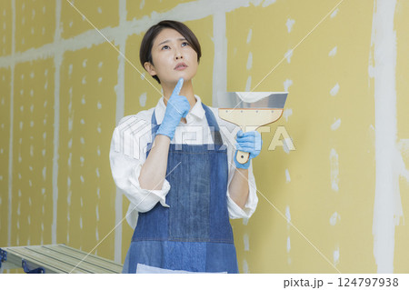 石膏ボードにパテをする女性 124797938