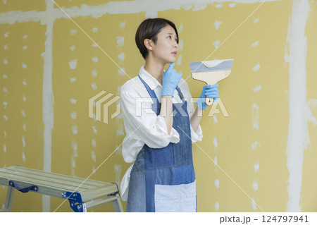 石膏ボードにパテをする女性 124797941