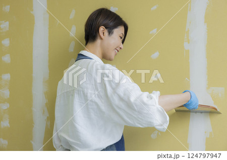 石膏ボードにパテをする女性 石膏ボードにパテをする女性 124797947