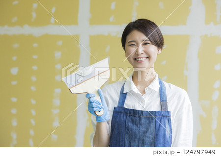 石膏ボードにパテをする女性 124797949
