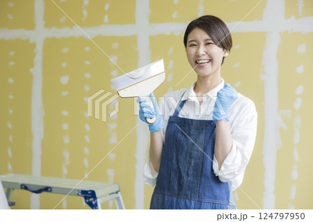 石膏ボードにパテをする女性 石膏ボードにパテをする女性 124797950