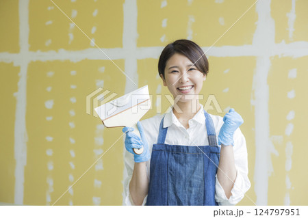 石膏ボードにパテをする女性 124797951