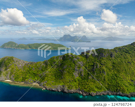 View of Inambuyod with blue sea from Matinloc Island. Blue sky clouds. El Nido, Philippines. 124798724