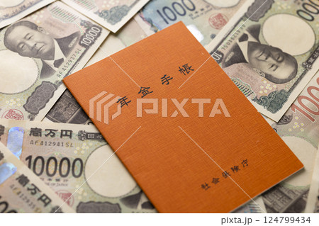 年金手帳と紙幣のイメージ 124799434
