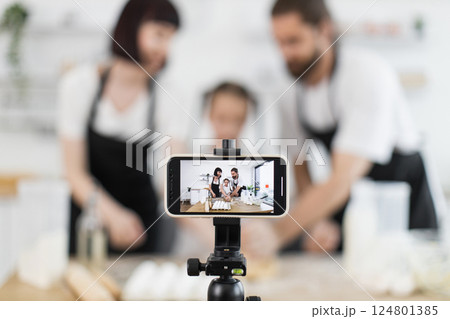 Caucasian adults with child creating cooking content for blogging during energetic photo session at home Caucasian adults with child creating cooking content for blogging during energetic photo session at home 124801385