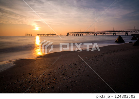 Beautifull sunrise over the sea and the broken pier - long exposure, low light. 124802502