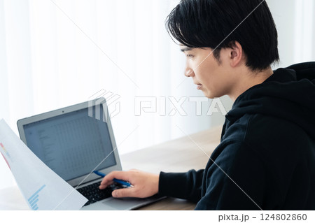 書類をチェックする若い男性 124802860