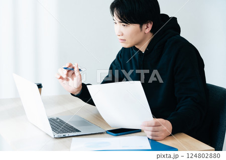 書類をチェックする若い男性 124802880