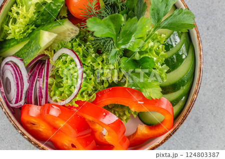 vegan salad from green leaves mix and vegetables in bowl. Healthy green vegetable salad, diet menu. Top view 124803387