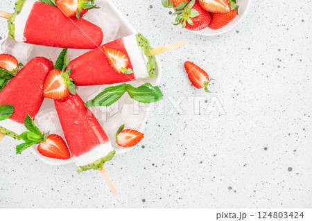 refreshing strawberry popsicles. Fruit ice with natural strawberry and kiwi on a light background, top view. copy space refreshing strawberry popsicles. Fruit ice with natural strawberry and kiwi on a light background, top view. copy space 124803424
