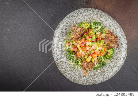 Delicious avocado and raw salmon salad, tartare. on a dark background. top view. copy space for text 124803499