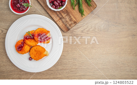 Baked Camembert brie crispy with fresh berries and cranberry sauce with rosemary. appetizer. top view. copy space 124803522