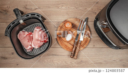 steaks from air fryer oven on a wooden background, inside the basket steaks from air fryer oven on a wooden background, inside the basket 124803587