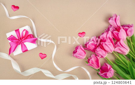 Beautiful bouquet of tulips flowers and gift box on beige pastel background. happy mothers day, top view. copy space 124803641