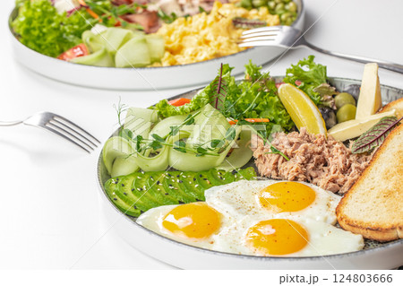 assortment of tasty breakfast platter with eggs and assorted dishes on Table 124803666