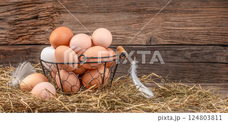basket of fresh chicken eggs on wooden table. eco poultry farm, free range chicken farm. Long banner format. copy space 124803811