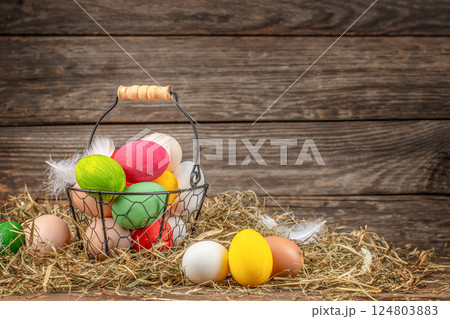 basket of Easter eggs farmer collects eggs at eco poultry farm on a wooden background basket of Easter eggs farmer collects eggs at eco poultry farm on a wooden background 124803883