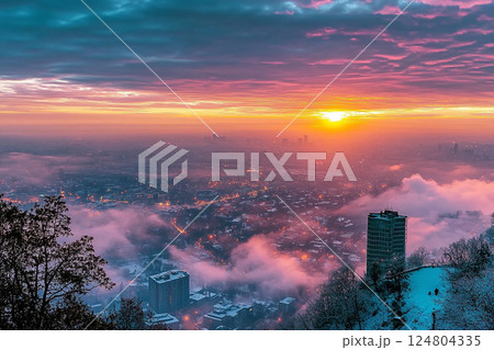A stunning view showcases a vibrant sunrise illuminating a city engulfed in mist. Snow-covered mountains frame the scene, creating a serene and picturesque atmosphere. A stunning view showcases a vibrant sunrise illuminating a city engulfed in mist. Snow-covered mountains frame the scene, creating a serene and picturesque atmosphere. 124804335