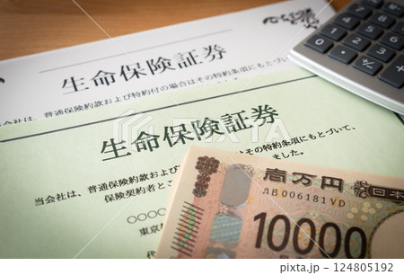 生命保険証券と一万円札と電卓　保険　保険証券　保険証書　相続対策　指定代理請求制度 124805192