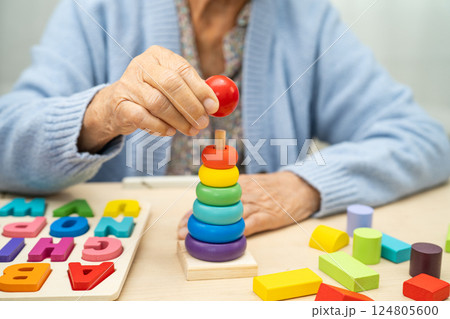 Alzheimer disease AD, Asian elderly woman patient suffering from dementia learn practical motor skills rehabilitation. Alzheimer disease AD, Asian elderly woman patient suffering from dementia learn practical motor skills rehabilitation. 124805600