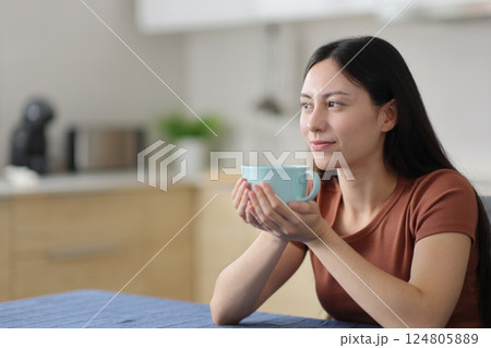 Asian woman looking away holding coffee cup Asian woman looking away holding coffee cup 124805889