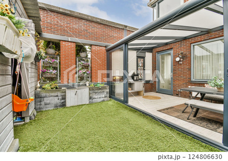 A contemporary outdoor patio featuring a modern design, stylish furniture, and lush greenery, ideal for relaxation and gatherings. A contemporary outdoor patio featuring a modern design, stylish furniture, and lush greenery, ideal for relaxation and gatherings. 124806630