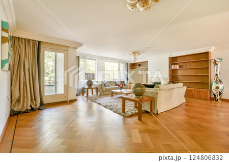 A bright and spacious living room featuring comfortable furniture, decorative elements, and large windows that allow natural light to fill the space. A bright and spacious living room featuring comfortable furniture, decorative elements, and large windows that allow natural light to fill the space. 124806832