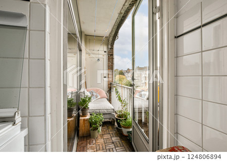 A charming balcony space adorned with greenery and comfortable seating, offering a peaceful retreat amidst urban surroundings. 124806894